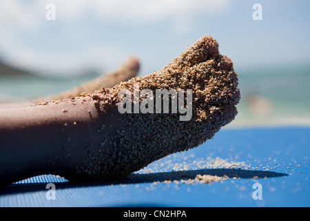 Bambino coperto i piedi nella sabbia Foto Stock