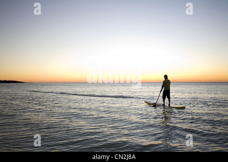 L'uomo Paddleboarding sull Oceano al Sunrise, Florida Keys, STATI UNITI D'AMERICA Foto Stock