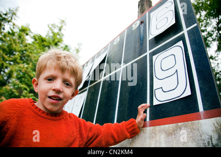 Giovane ragazzo giocando con i numeri sul tabellone Foto Stock