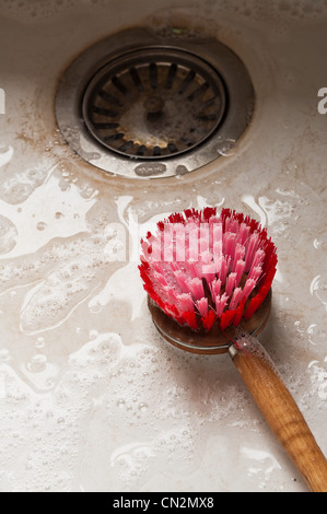 Spazzola per il lavaggio di stoviglie nel lavello da cucina Foto Stock