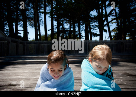 Due bambini avvolti in asciugamani Foto Stock