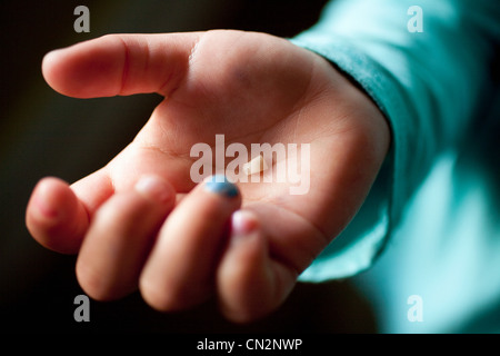 Ragazza del dente di trattenimento nel palmo della mano, close up Foto Stock