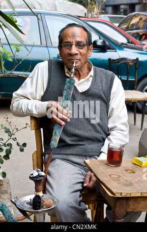 Uomo di fumare Narghilé centro cittadino del Cairo Foto Stock