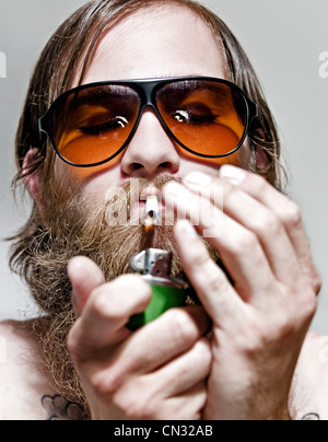 Ritratto di giovane uomo sigaretta illuminazione, close up Foto Stock