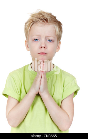 Affascinante kid mettere le mani insieme come se a mendicare per qualcosa di Foto Stock