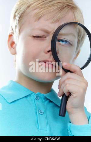 Ritratto di un bambino guardando attraverso la lente di ingrandimento Foto Stock