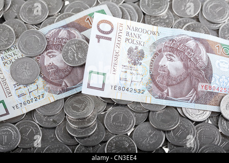 Dieci zloty polacco di carta moneta posa su uno zloty polacco monete. Il denaro e il concetto di risparmio. Foto Stock