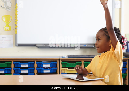 School girl risposta alla domanda mentre si utilizza il computer portatile in aula Foto Stock