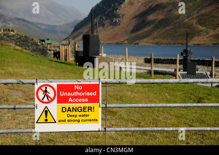 Segnale di avvertimento per indicare le acque profonde e forti correnti accanto a un lago nel distretto del lago Foto Stock