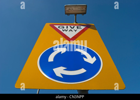 British cartello stradale che indica una rotatoria dove si avvicinano gli autisti dovrebbero dare modo Foto Stock