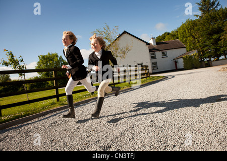 Ragazzi in esecuzione lungo il sentiero di ghiaia di ranch Foto Stock