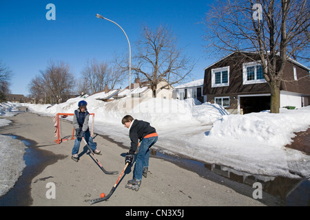 Canada, Provincia di Quebec, Montreal Laval sobborgo di Montreal, ragazzi che giocano a hockey su strada in una zona residenziale Foto Stock