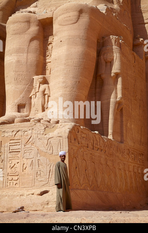 Egitto - Abu Simbel Tempio Egiziano, uomo in piedi sotto Ramses II statua, UNESCO Foto Stock