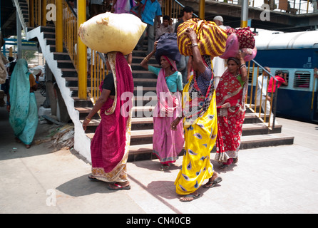 Le donne che trasportano merci presso una stazione ferroviaria in Dehli, India Foto Stock