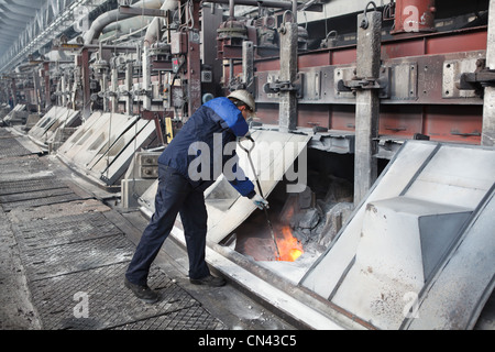 Alluminio impianto metallurgico con bagni di elettrolisi. Lavoratore in prossimità di fiamme. Non ferrosi metallurgia russa. Foto Stock