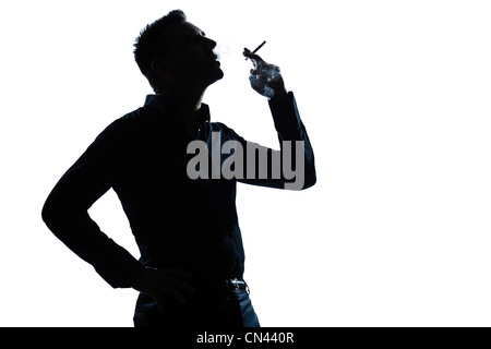 Un uomo caucasico ritratto il fumo di sigaretta in silhouette studio isolato sfondo bianco Foto Stock