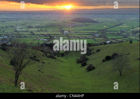 Un tramonto dorato oltre i livelli di Somerset visto da Batcombe cava. Foto Stock