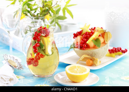 Deliziosa frutta fresca servita nella ciotola di melone come dessert con limonata Foto Stock