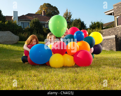 Le ragazze dietro i palloncini multicolori Foto Stock