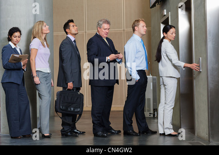 Gli imprenditori in attesa nella coda per ascensore Foto Stock