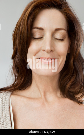 Felice e rilassato donna con gli occhi chiusi Foto Stock