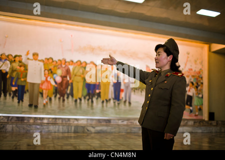 Corea del Nord Pyongyang, Patria vittoriosa guerra di liberazione Museum, femmina guida soldato che descrive un affresco che mostra Kim Foto Stock