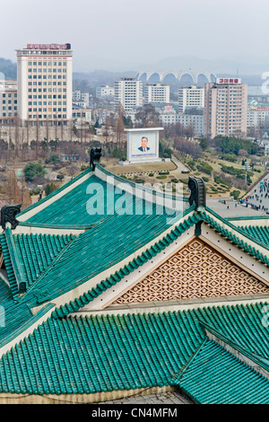 Corea del Nord Pyongyang, Grand popolare casa di studio, piastrelle verdi tetti e ritratto di Kim Il-Sung in un parco a distanza Foto Stock