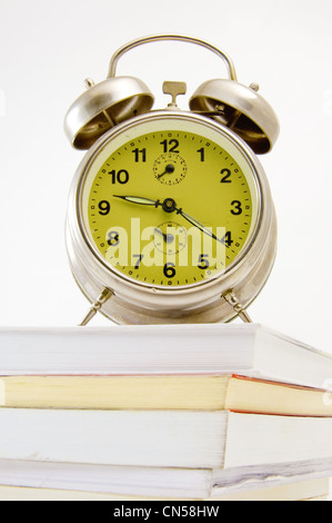 Vecchio, vintage orologio sulla parte superiore dei libri, immagine è presa su uno sfondo bianco Foto Stock