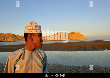 Il sultanato di Oman, Al Batinah Regione, Al Sawadi, la spiaggia, giovane con dichdacha (thawb o thobe) e koumma (tradizionale Foto Stock