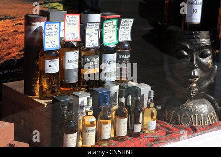 Bottiglie di Scottish malt whisky in una finestra di visualizzazione per la vendita in un negozio a Peebles in Scottish Borders Foto Stock