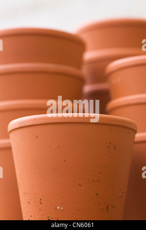 Una pila di vasi in giardino contro una parete bianca. Foto Stock