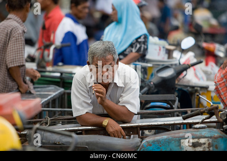 Un motociclo taxi driver in attesa per gli scambi al di fuori del mercato centrale di Songkhla, Thailandia Foto Stock