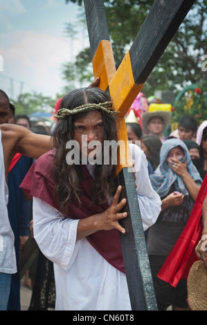 Personaggio principale porta la croce per la crocifissione Cutud sito durante il tradizionale crocifissioni tenutasi il Venerdì Santo, Foto Stock