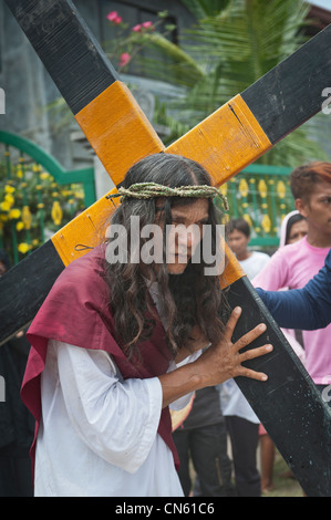 Personaggio principale porta la croce per la crocifissione Cutud sito durante il tradizionale crocifissioni tenutasi il Venerdì Santo Foto Stock