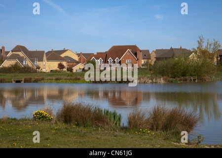 Case accanto al lago Ewart Cambourne Country Park Cambridgeshire Inghilterra Foto Stock