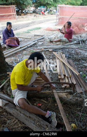 I pescatori preparare il legno per costruire nuove gabbie di pesca presso un villaggio di pescatori sul lago Songkhla. Il lago è poco profondo e le gabbie di sedersi sul letto del mare. Della Thailandia Foto Stock