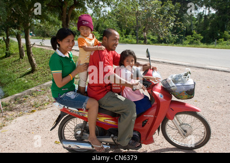 Un padre ed una madre a portare i loro due bambini a casa da scuola da moto, Songkhla, Thailandia Foto Stock