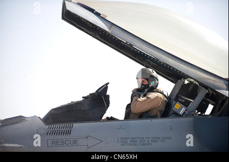 U.S. Air Force Big. Scott Dennis, pilota F-16C e comandante della 451esima Ala aerea, mette sulla sua maschera di ossigeno prima dell'avviamento del motore, Kandahar Airfield, Afghanistan, 5 aprile 2012. La missione del 451esimo Squadrone Expeditionary Fighter è quella di fornire energia aerea decisiva sul bersaglio, in tempo. Foto Stock