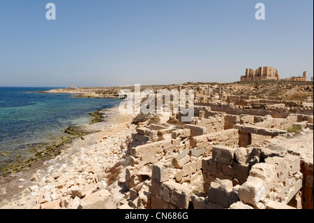 Sabratha. La Libia. Vista parziale di alcuni del romano quartiere residenziale di antico sito con lo splendido teatro sul lontano Foto Stock