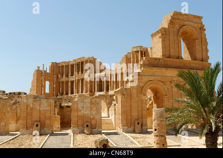 Sabratha. La Libia. Vista parziale di una sezione di conformazione arcuata anello esterno - con edificio stadio nella parte posteriore- del teatro romano Foto Stock