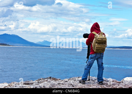 Wildlife Photographer traveler godendo di vista oceano dalla cima della montagna, escursioni per backpacker e scattare foto Foto Stock