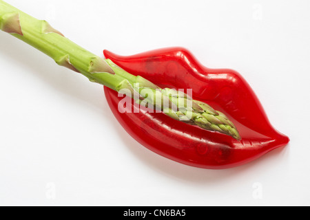 coppia di taglierina per vino a labbra rosse con stelo singolo in punta di asparagi su sfondo bianco - concetto di consumo di verdure di asparagi Foto Stock