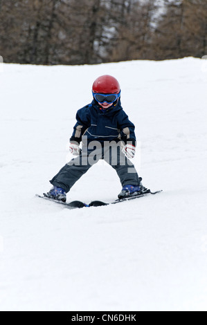 Un giovane ragazzo sciare sulle piste da se stesso Foto Stock