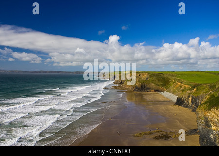 Due persone a piedi su quasi deserte DruidstoneBeach vicino ampio Haven, Pembrokeshire, Galles Foto Stock