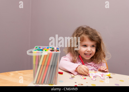 Bimba di tre anni la colorazione con pennarelli. Foto Stock