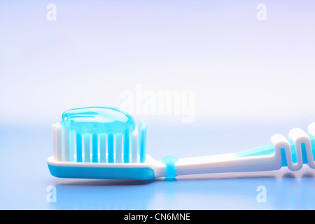 Blue spazzolino da denti con dentifricio blu su sfondo blu Foto Stock