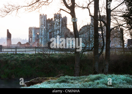 Le rovine del castello di Cowdray in Cowdray Park, Midhurst, West Sussex di prima mattina con la brina sulla terra 'n' di pesca Foto Stock