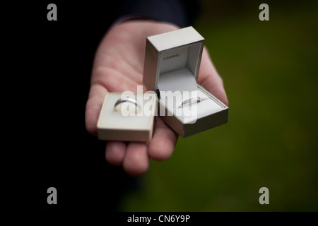 Due anelli sono tenuti in sposi mano prima di un matrimonio. Foto Stock