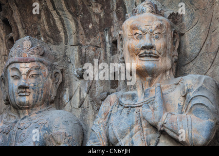 Statue di Buddha i suoi discepoli in Fengxian grotte presso il Le Grotte di Longmen sito in Cina Foto Stock