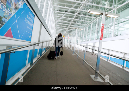 Una donna sola i passeggeri all'aeroporto di Stansted Essex REGNO UNITO Foto Stock